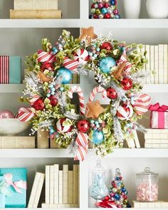 a christmas wreath sitting on top of a book shelf next to other books and decorations