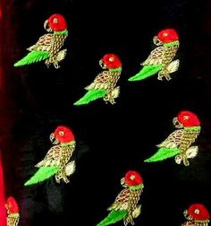 several red and green birds on black fabric