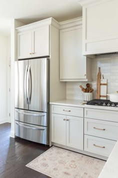 a kitchen with white cabinets and stainless steel appliances