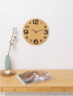 a wooden clock sitting on top of a table next to a vase filled with flowers