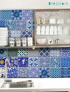 a kitchen with blue and white tiles on the wall