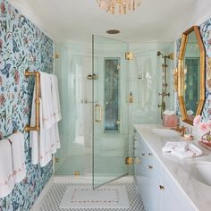 a bathroom with floral wallpaper and gold fixtures