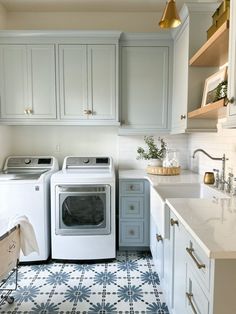 a white washer and dryer in a kitchen with blue floor tiles on the floor