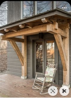 a rocking chair sitting on top of a wooden porch next to a door and windows