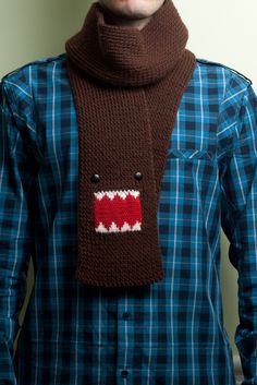 a man wearing a knitted scarf with an ugly red and white monster on it