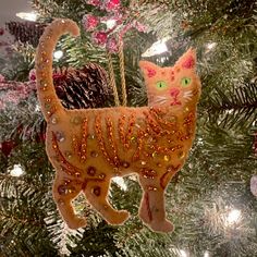 a cat ornament hanging from a christmas tree