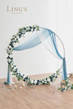 a white and blue wedding arch decorated with flowers