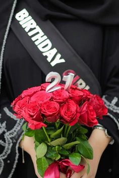 a woman holding a bouquet of red roses with the number twenty two on her shirt