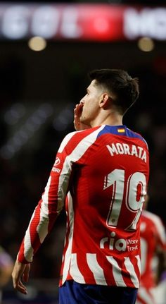 a soccer player with his head in the air, looking up at something while standing next to him