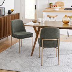 a dining room table with two chairs next to it