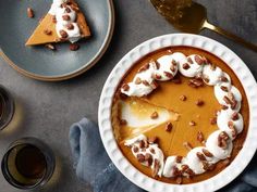 there is a pie on the plate with whipped cream and pecans in front of it