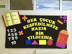 a bulletin board with an open book on it's side and other school supplies