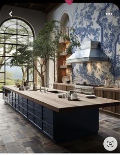 a large kitchen with blue and white wallpaper on the walls, an island in the middle