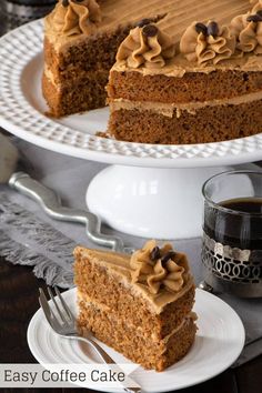 a piece of cake on a plate with a fork and cup of coffee in the background