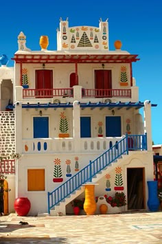 a white building with red and blue balconies