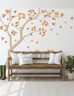 a wooden bench sitting in front of a tree with fall leaves on it's branches