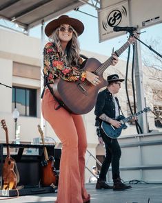 a woman with a guitar on stage