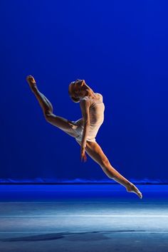 a ballerina in the air with her legs spread out