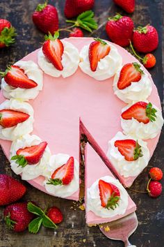 a cake with strawberries and whipped cream on top is cut in half to show the inside