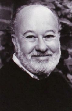 an old black and white photo of a man with a beard smiling at the camera