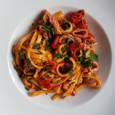 a white plate topped with pasta and meat