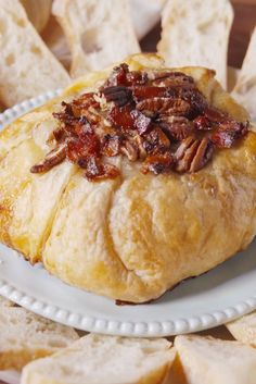 a pastry with pecans on it sitting on a plate next to some crackers