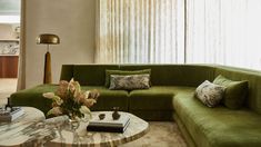 a living room filled with green couches and pillows