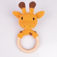 a crocheted giraffe toy with a wooden ring