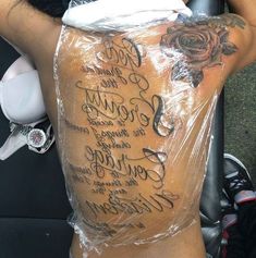 the back of a man's body covered in plastic with words written on it