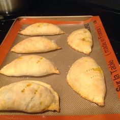 four uncooked pita breads sitting on a baking sheet in an oven