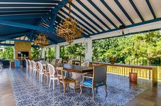 an outdoor dining area with blue and white tile flooring, chandelier and chairs