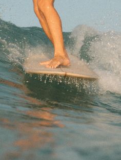 a man riding a surfboard on top of a wave