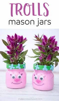 two pink mason jars with purple flowers in them and the words trolls mason jars