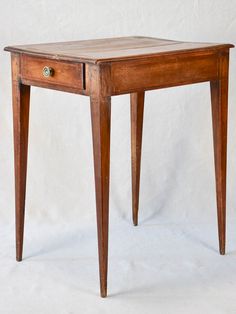 a small wooden table with two drawers on one side and an open drawer on the other