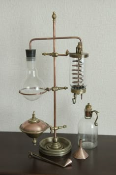 an old fashioned science experiment set up on a table with some glass and metal items