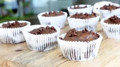 six chocolate cupcakes sitting on top of a wooden table