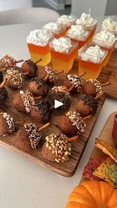 several desserts and drinks are sitting on a table with pumpkins in the background