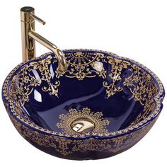 a blue and gold bowl sink with an ornate design on the rim, in front of a faucet