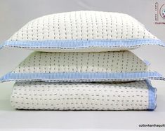 three pillows stacked on top of each other in front of a white background with blue trim