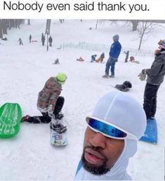 a group of people riding snowboards down a snow covered slope