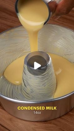 someone pouring milk into a metal pan on top of a wooden table with the words condenseed milk