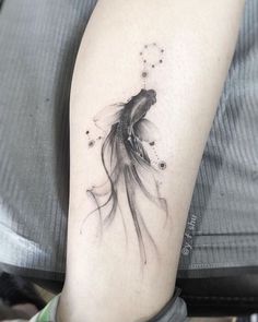 a black and white photo of a goldfish tattoo on the right arm, with bubbles coming out of it