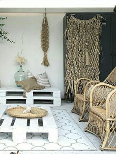 a living room filled with lots of wicker furniture next to a wall mounted plant