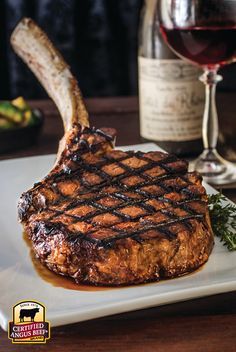 a steak on a plate next to a glass of wine