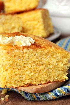 a piece of cornbread on a blue and white plate with a wooden spoon next to it