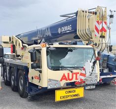 a large truck parked in a parking lot next to other trucks and equipment on the ground