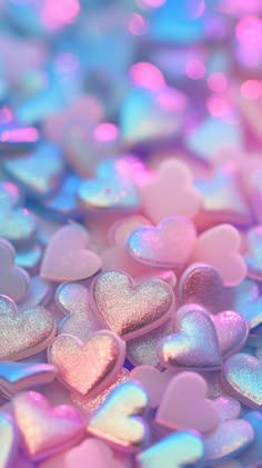 many heart shaped candies are scattered on top of each other in pink and blue