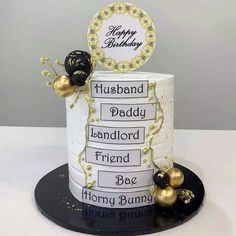 a birthday cake that is decorated with gold and black decorations, including a name tag