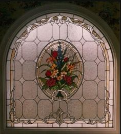 a stained glass window with flowers in the center and an ornate frame around it's edges