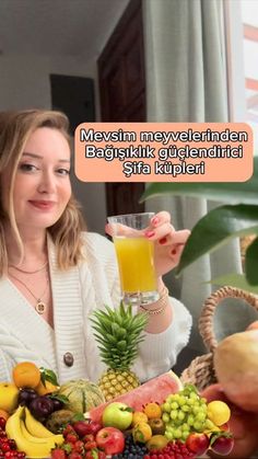 a woman holding a glass filled with fruit